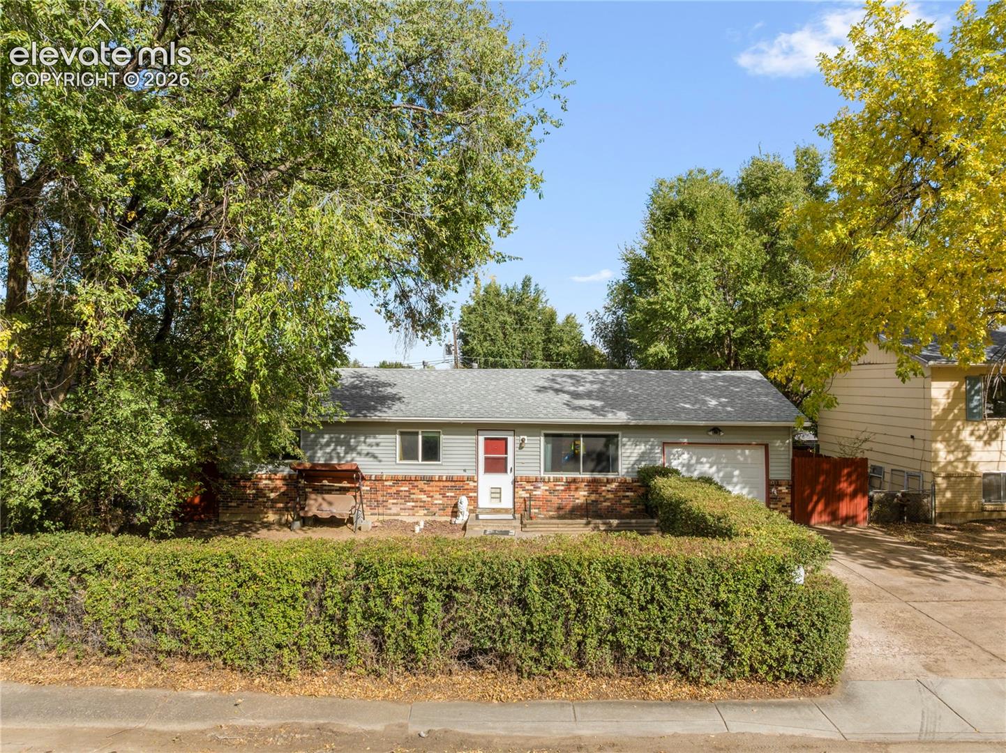 Fully fenced in front yard with hedges for privacy