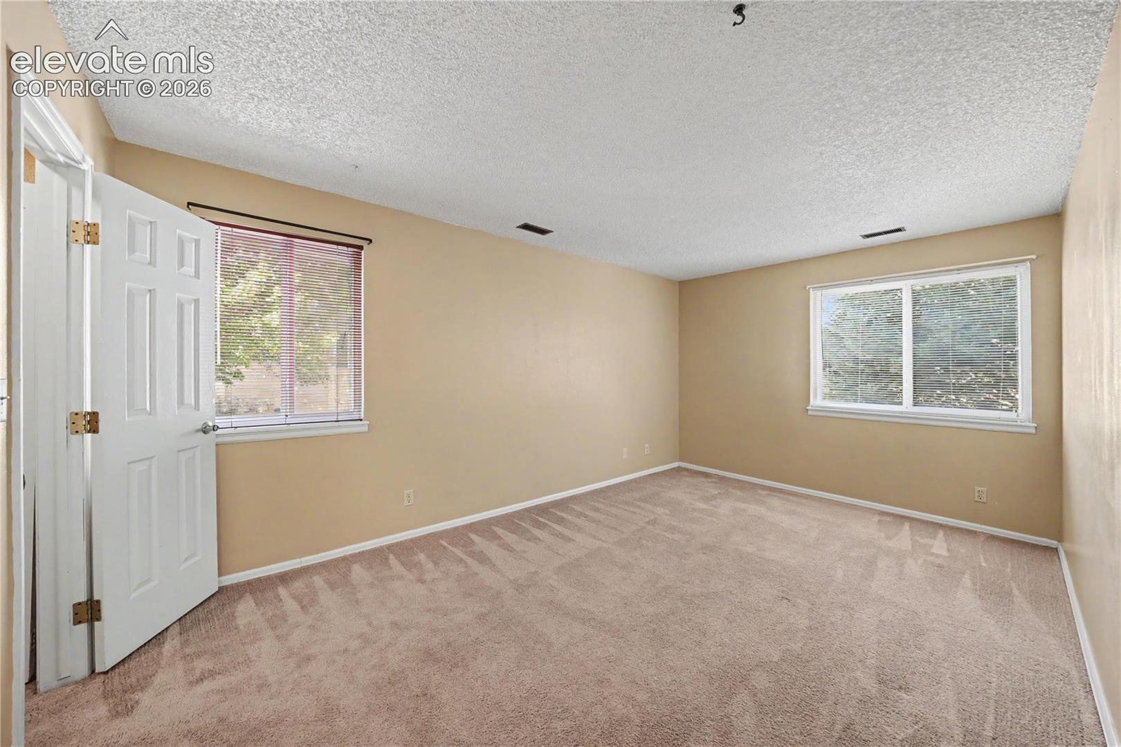 Bedroom with windows and carpeted floors
