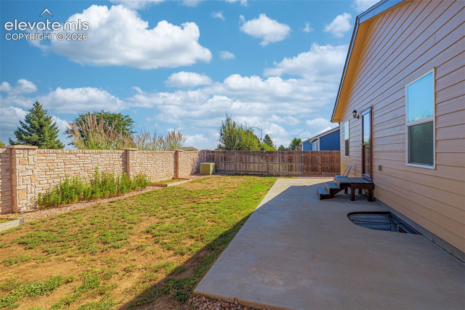 Concrete patio with direct exterior access and a stone accent wall