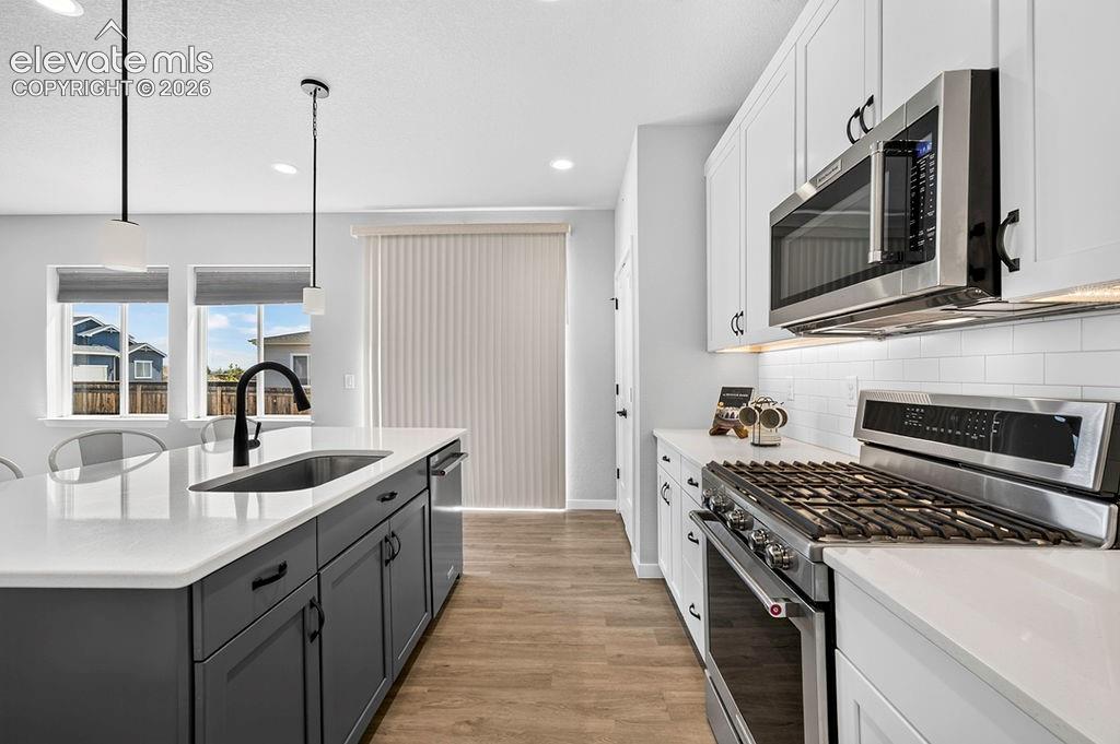 Modern kitchen featuring a large island with an undermount sink and matte black faucet