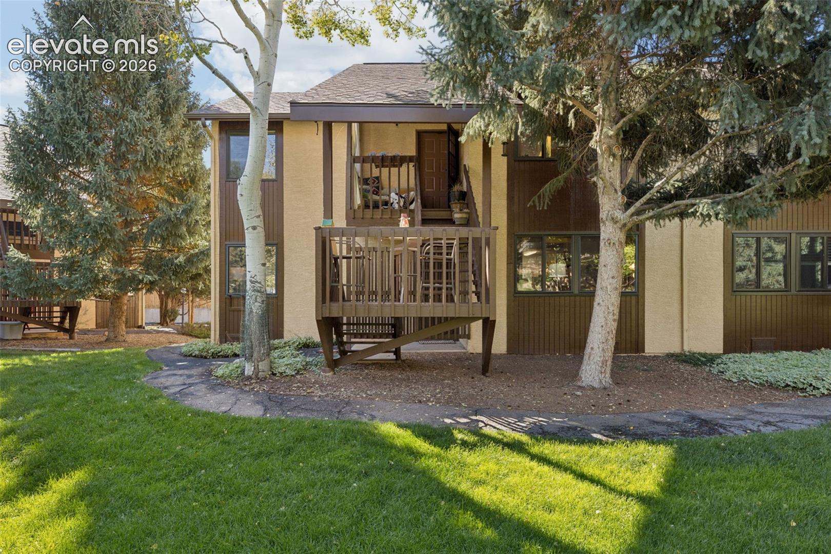 Two-story exterior with a wood deck, natural wood accents, and a sloped roof