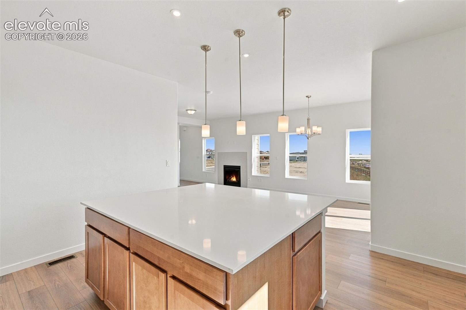 Kitchen island with a light-toned countertop and wood-finish cabinetry