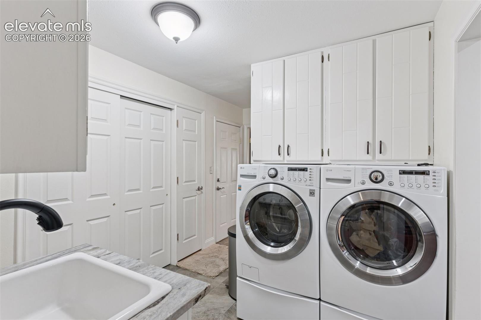 Laundry Room conveniently located off of garage with storage space and farmhouse sink