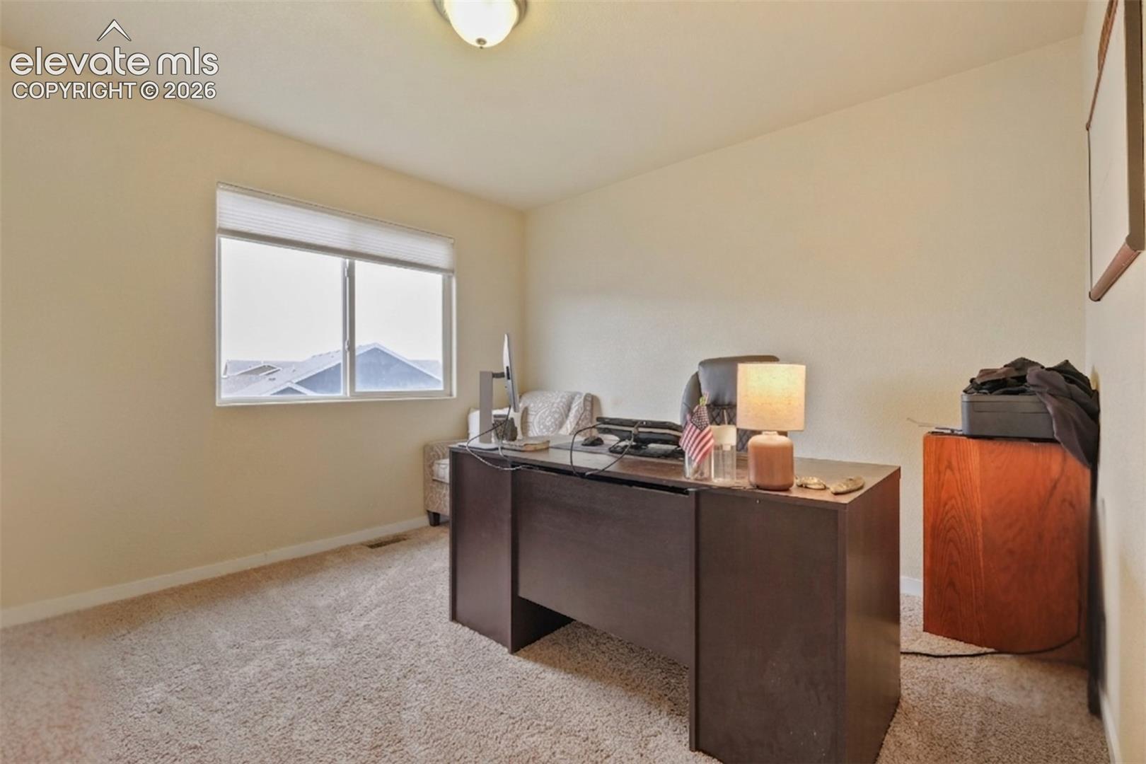 Upper Level: bedroom featuring a double window with blinds, neutral carpeting, and light-toned walls