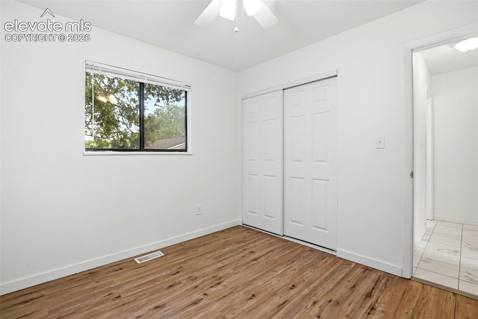 Could also be a Bedroom.  Wood-finish flooring, white walls, and a window with blinds