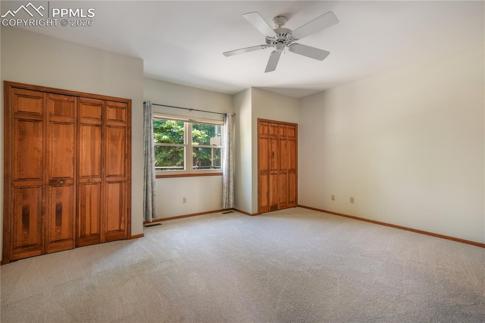 Main level primary bedroom with new carpet, ensuite 5 piece bathroom, walk in closets