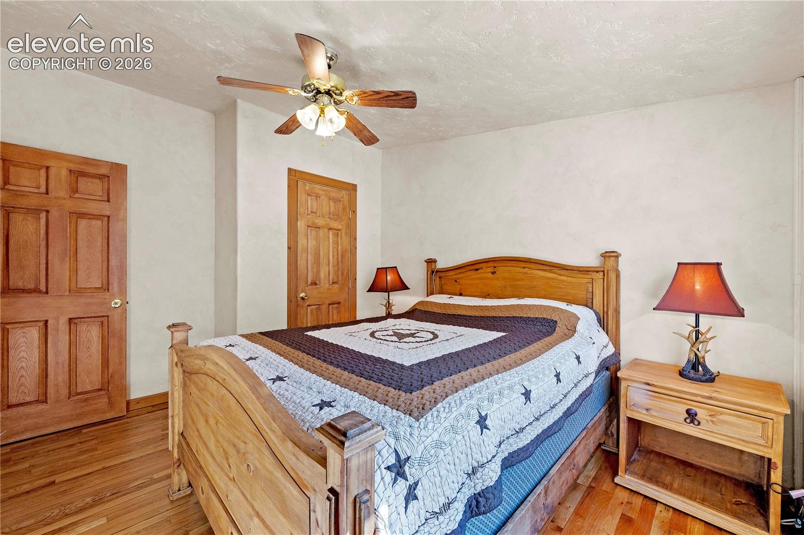 Bedroom featuring light hardwood / wood-style flooring, a textured ceiling, and ceiling fan