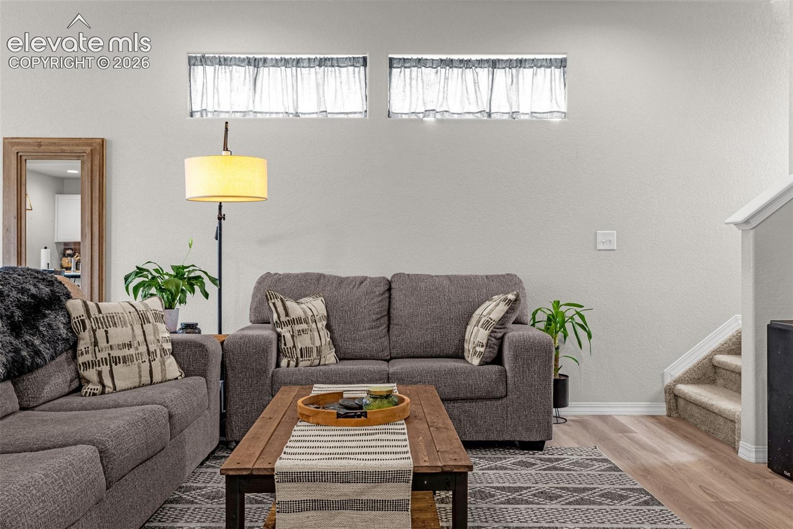 Living area featuring two high transom windows with sheer curtain panels
