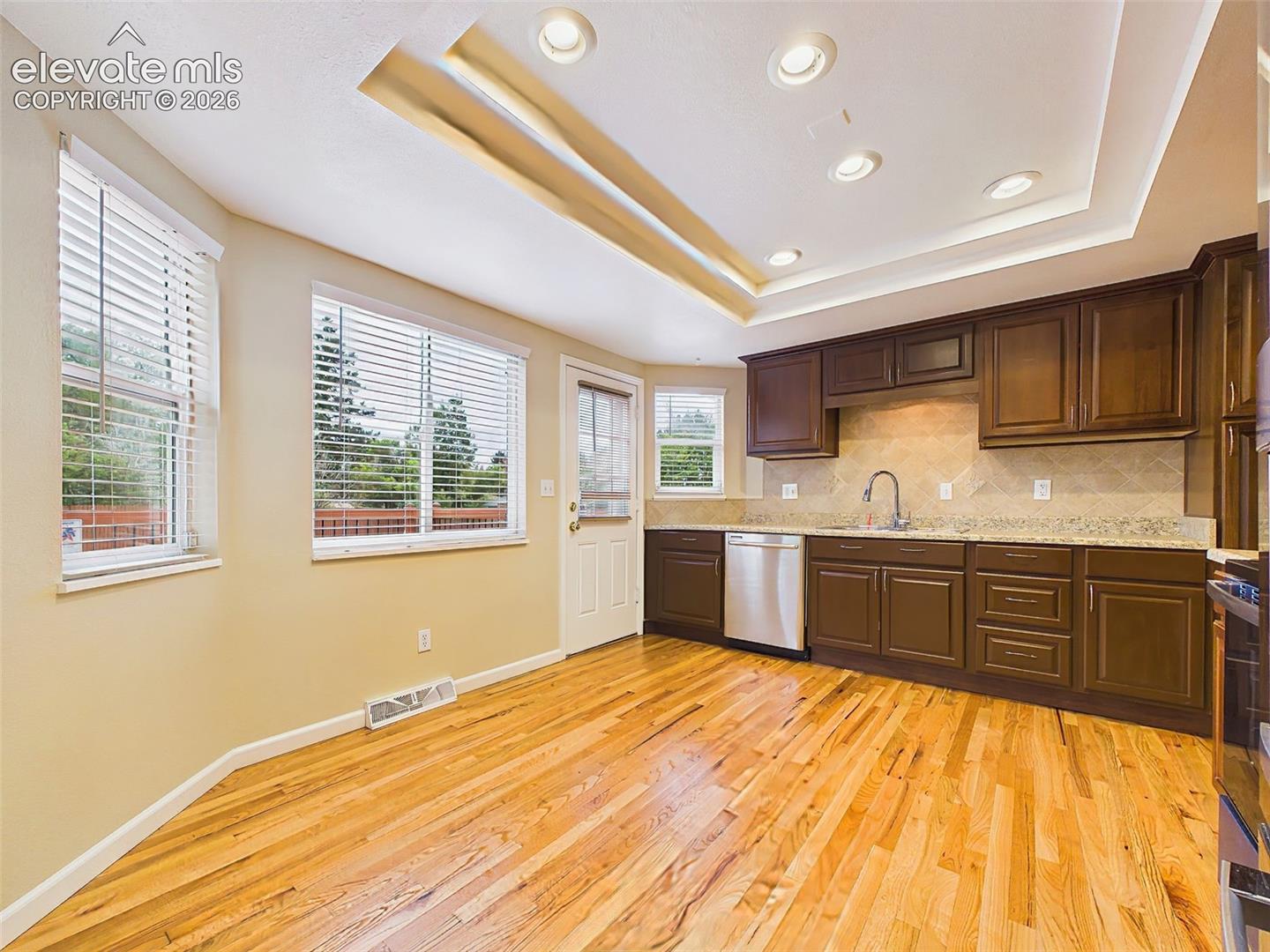 Formal dining room with contemporary lighting and hardwood flooring, seamlessly connected to the spacious living room for easy entertaining.