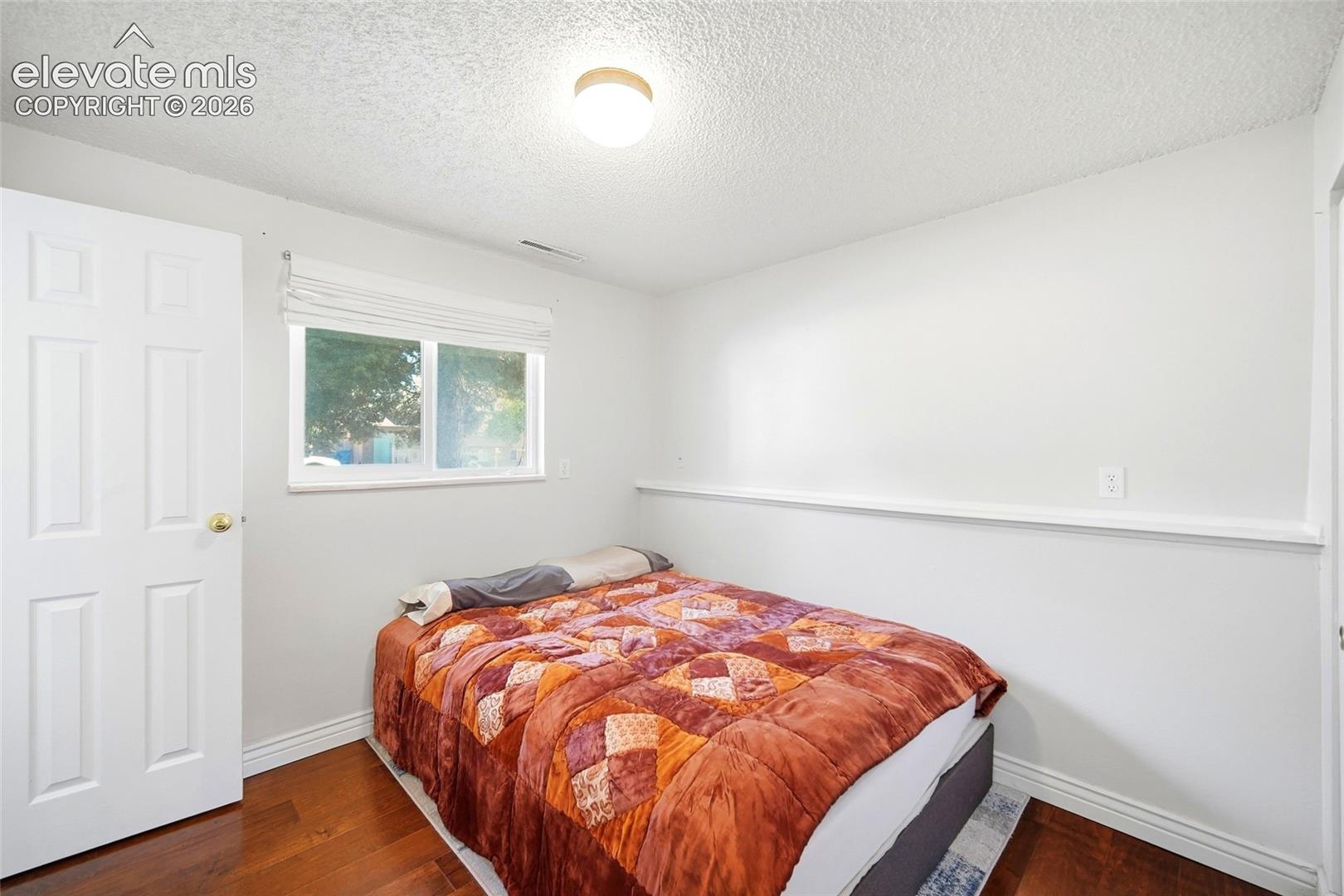 Lower level bedroom with wood flooring
