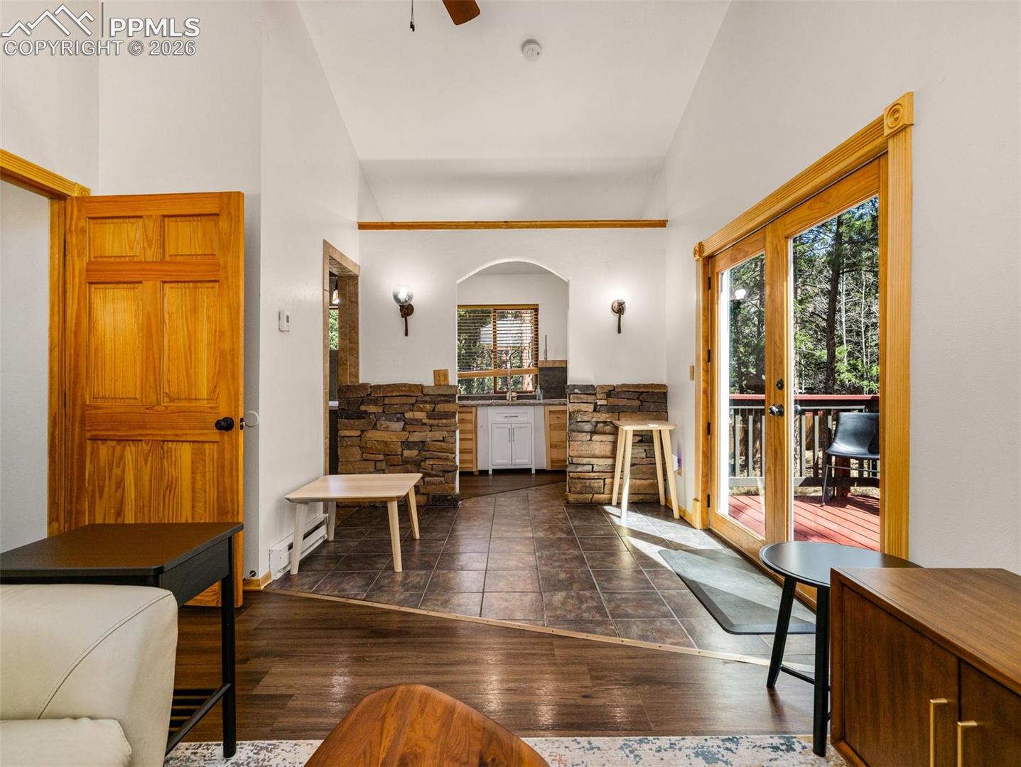Foyer entrance featuring dark wood-style flooring, vaulted ceiling, french doors, a ceiling fan, and a baseboard radiator