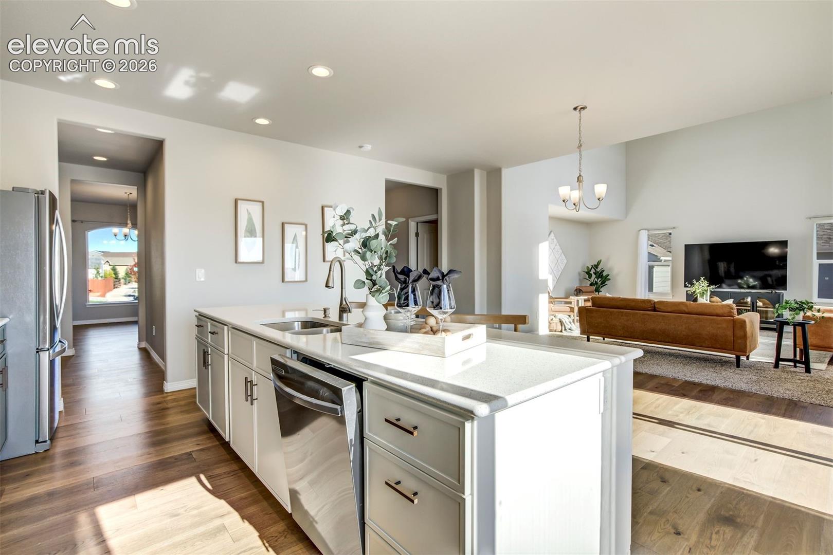 Kitchen island with a stainless steel sink, a pull-down faucet, and an integrated dishwasher