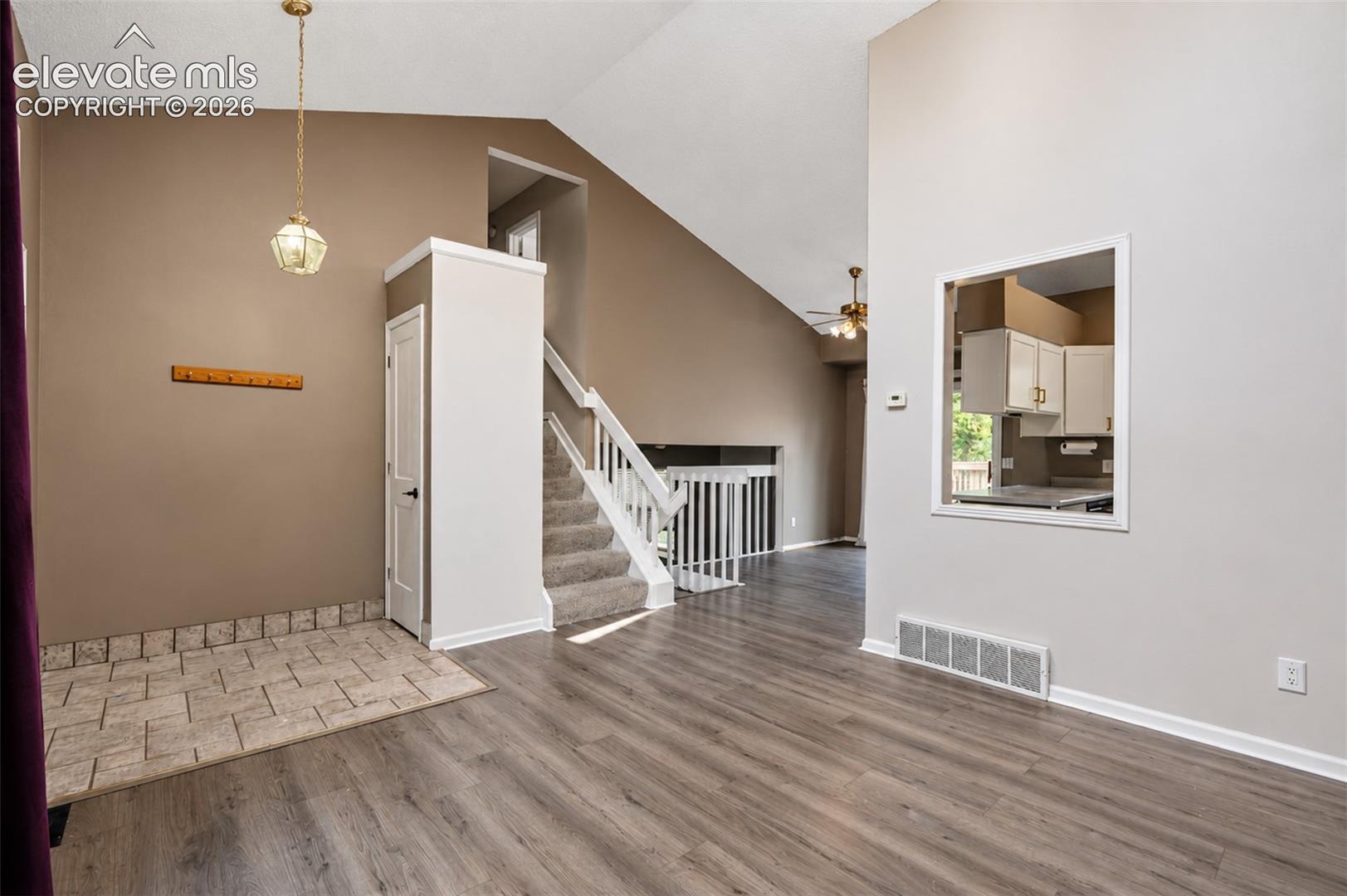 Living Room with High Ceilings and Kitchen Access.