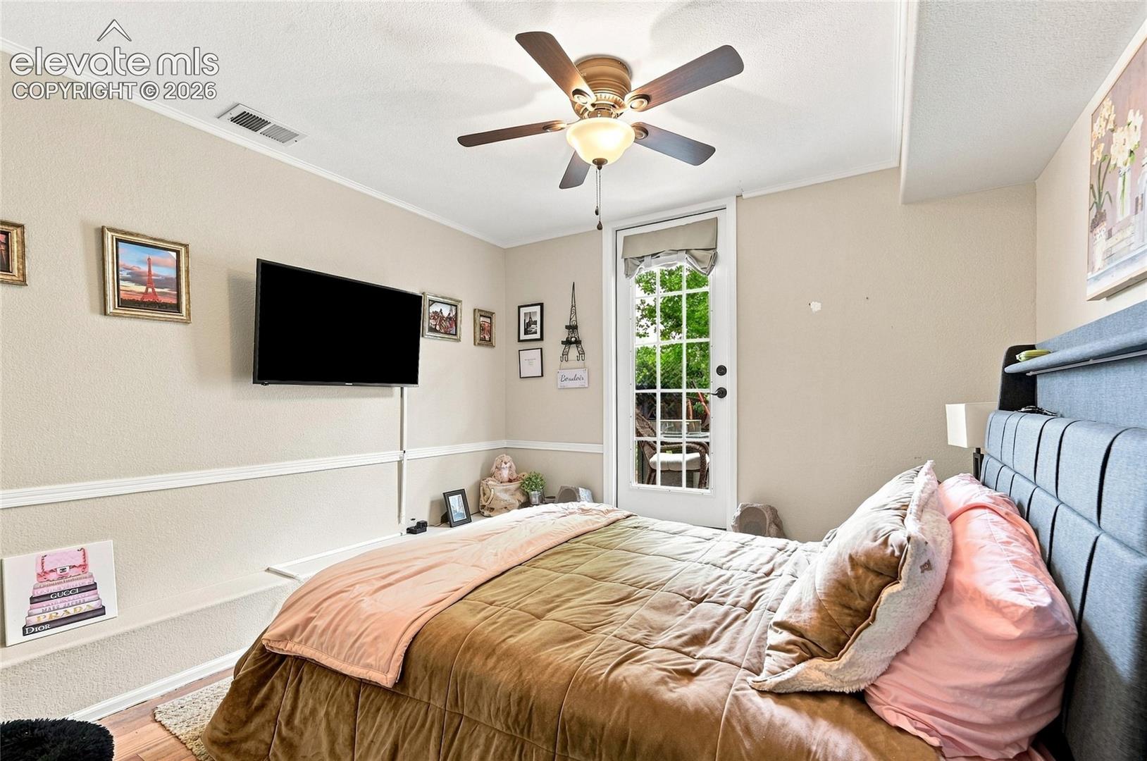 Room featuring chair rail molding, a multi-blade ceiling fan with integrated lighting, and a glass-paneled exterior door