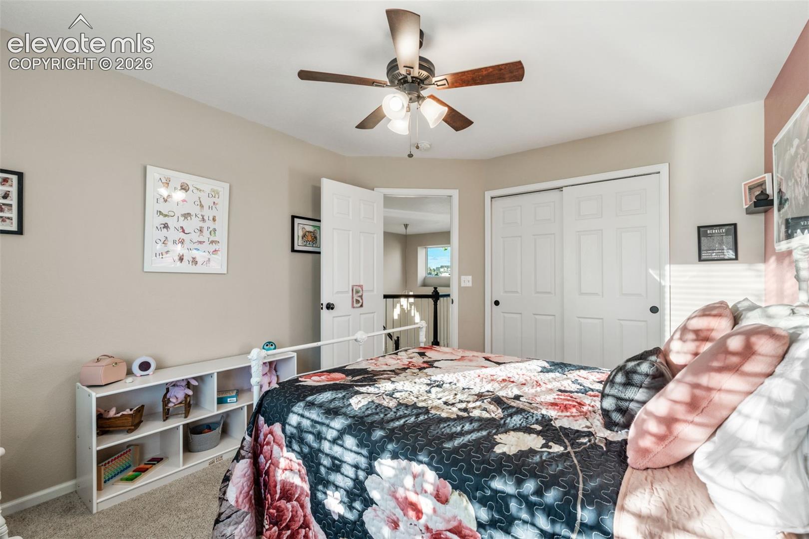 Neutral wall color, ceiling fan with integrated light fixture, and white dual-panel closet doors