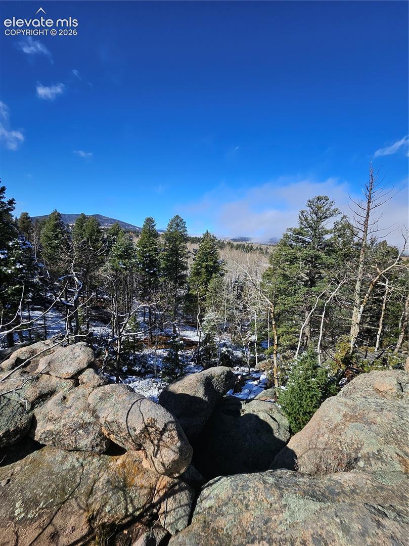 Rugged natural rock outcroppings, evergreen and deciduous trees, and mountainous terrain