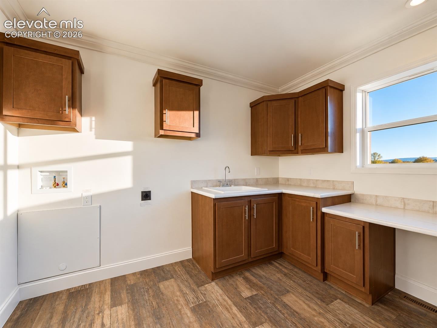 Laundry Area – Dedicated laundry hookups are complemented by a utility sink, generous cabinetry, and ample counter space, providing excellent storage and workspace.