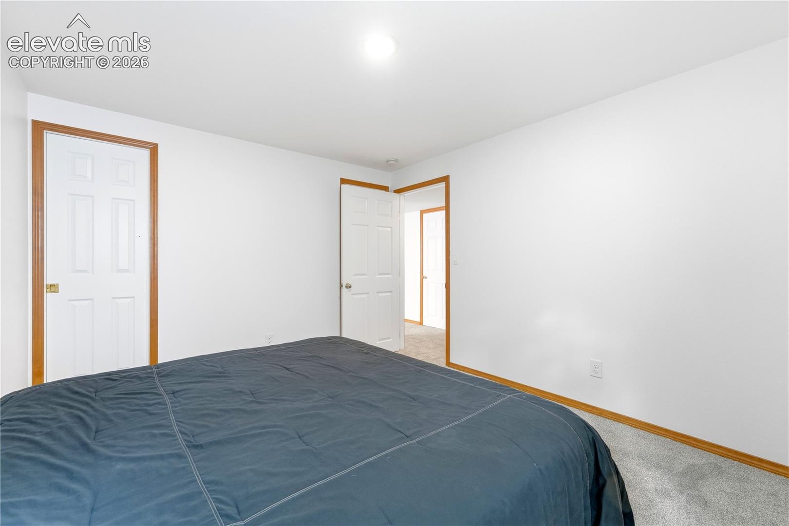 Spacious room featuring light-colored carpeting, white walls, and a window well