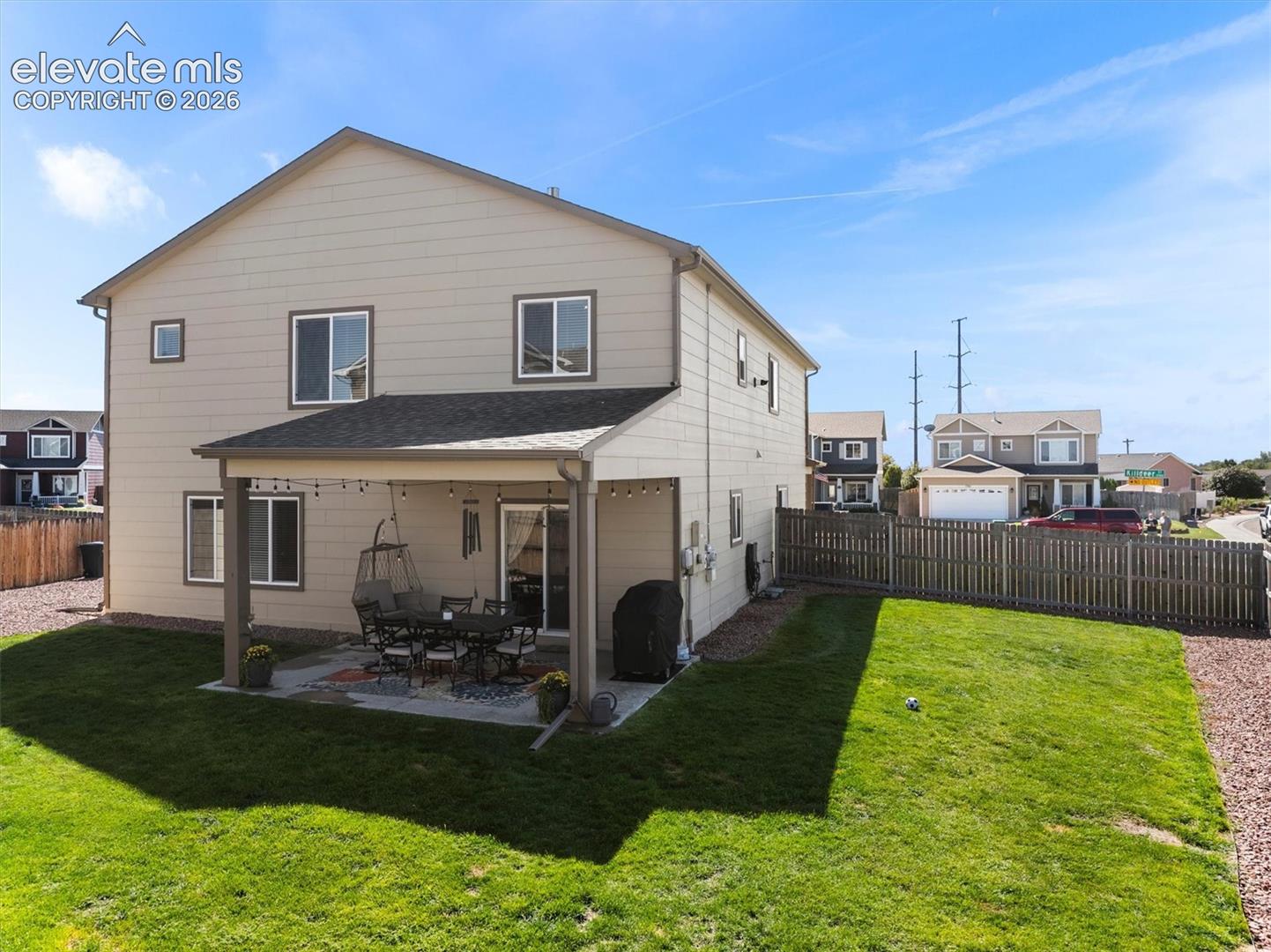 Two-story residence with a covered patio, fenced yard, and a slider door