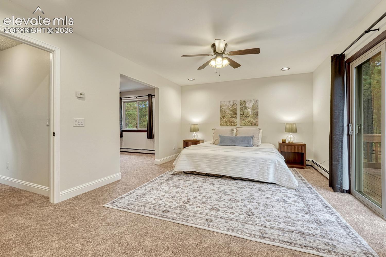 Carpeted room featuring a ceiling fan with integrated lighting, recessed lighting, and a sliding glass door providing external access