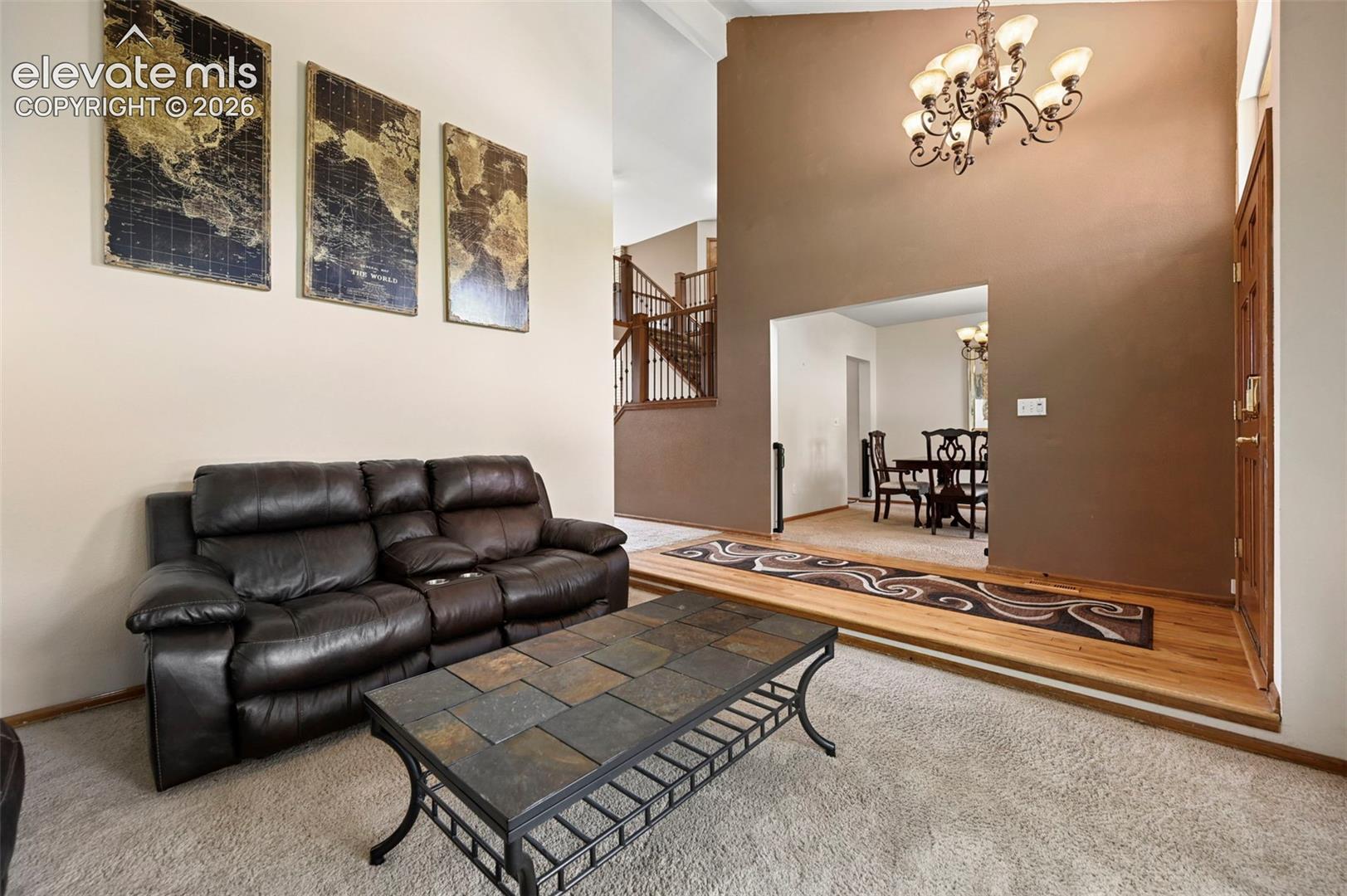Two-story foyer with a decorative chandelier, and an entry to a formal dining area