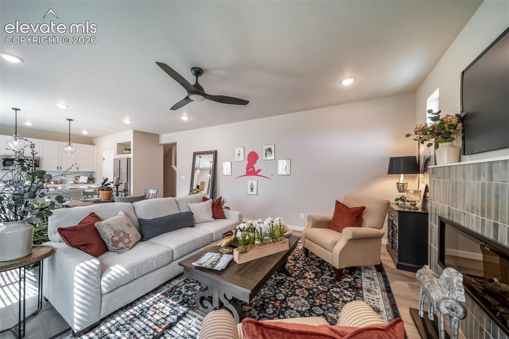 Living area featuring a ceiling fan, recessed lighting, and wood-finish flooring
*Photos of a model home*