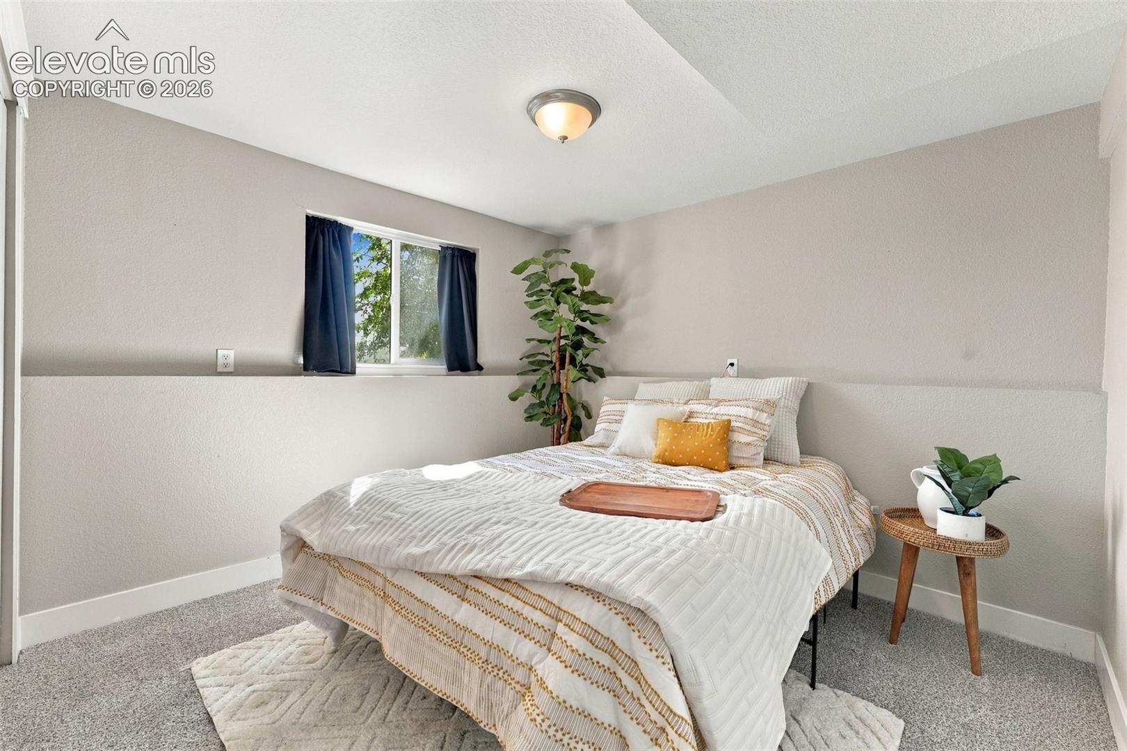 Recessed window, textured walls, overhead lighting, and carpeted flooring