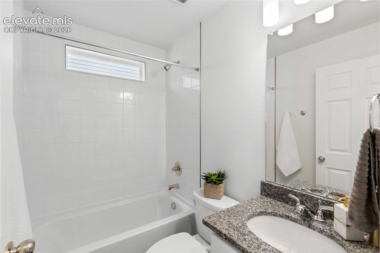 White tile bath/shower combination with an integrated window
*photos of a model home*