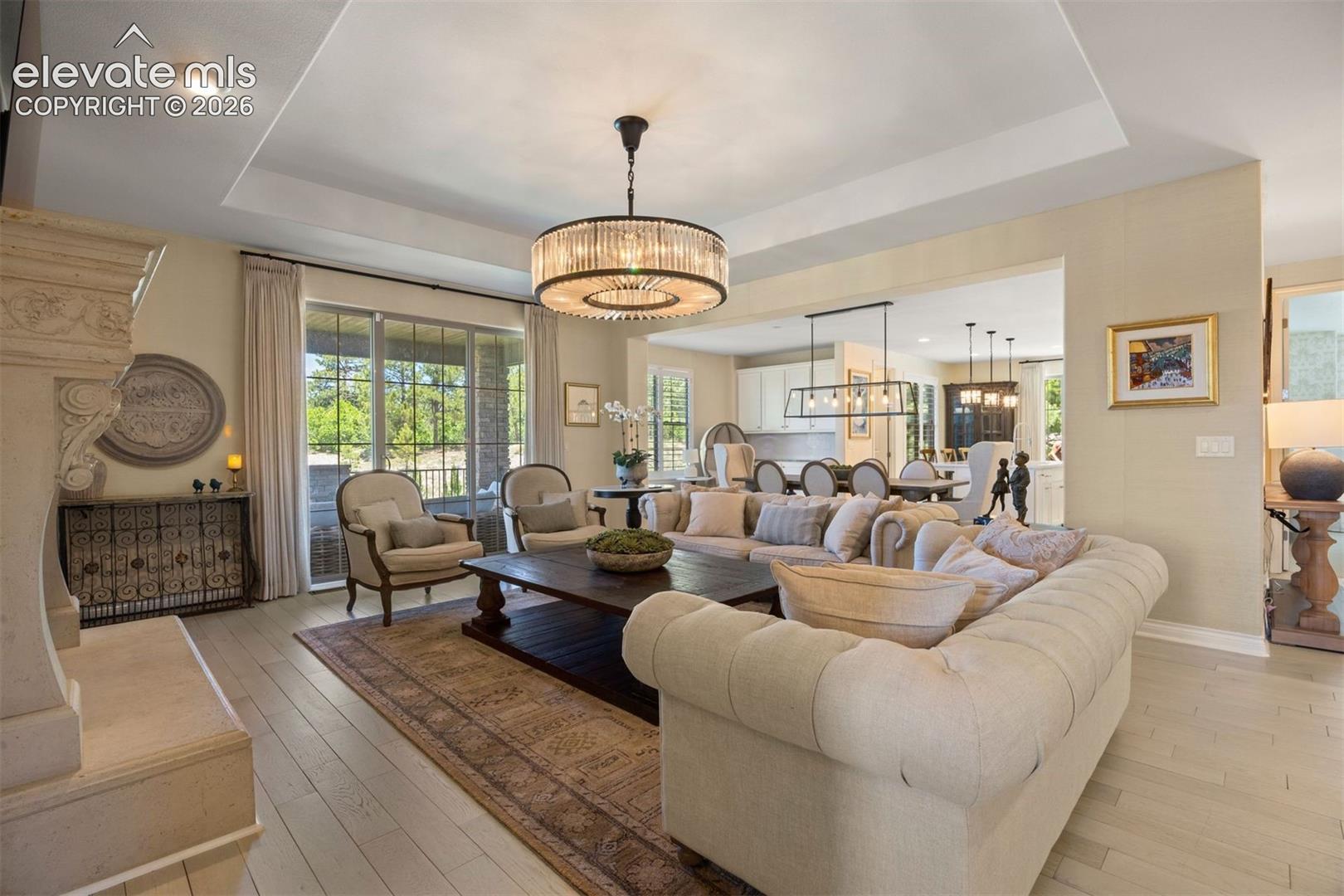 Spacious living area featuring light wood-finish flooring and a tray ceiling