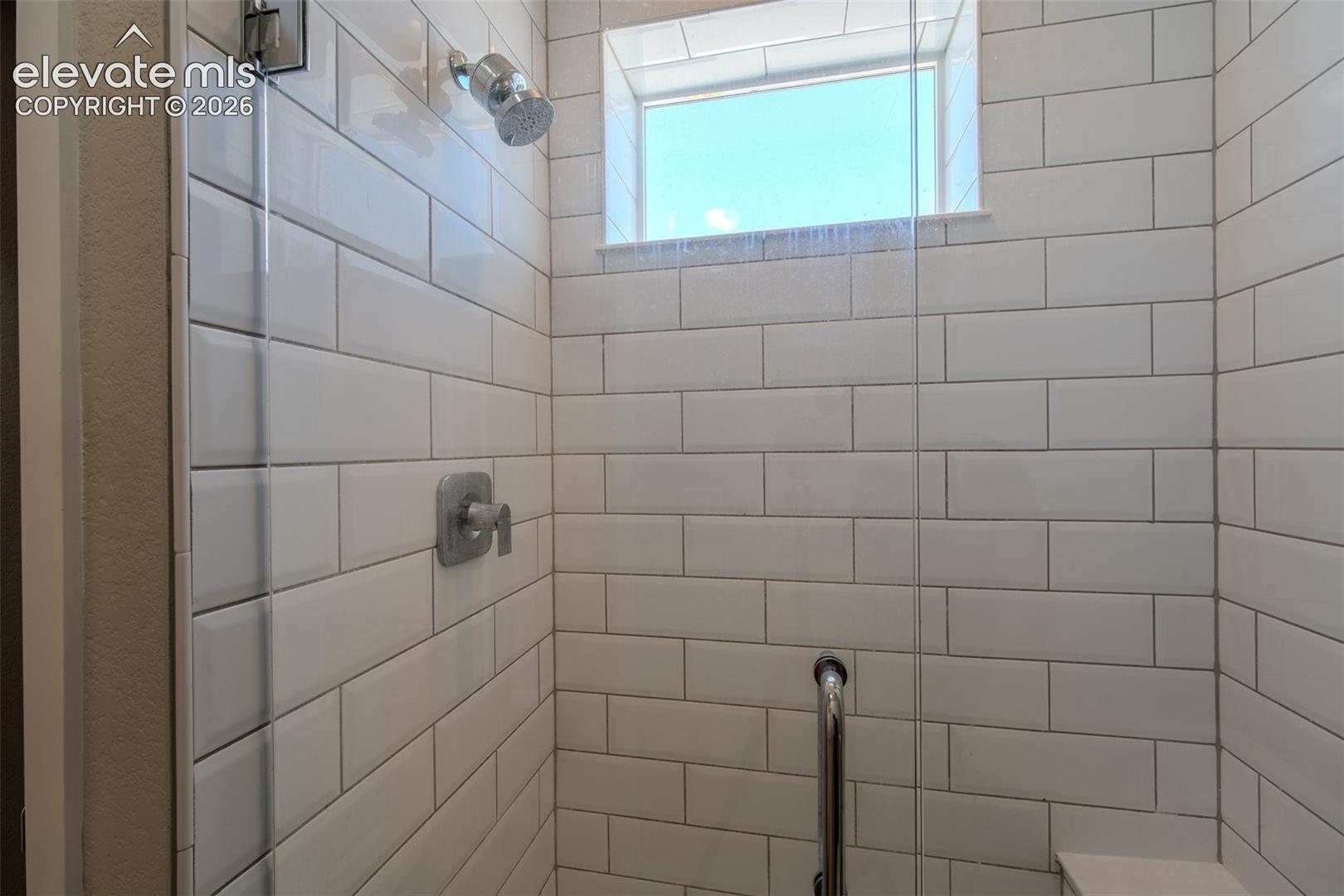 White subway tiled shower with built-in sink.