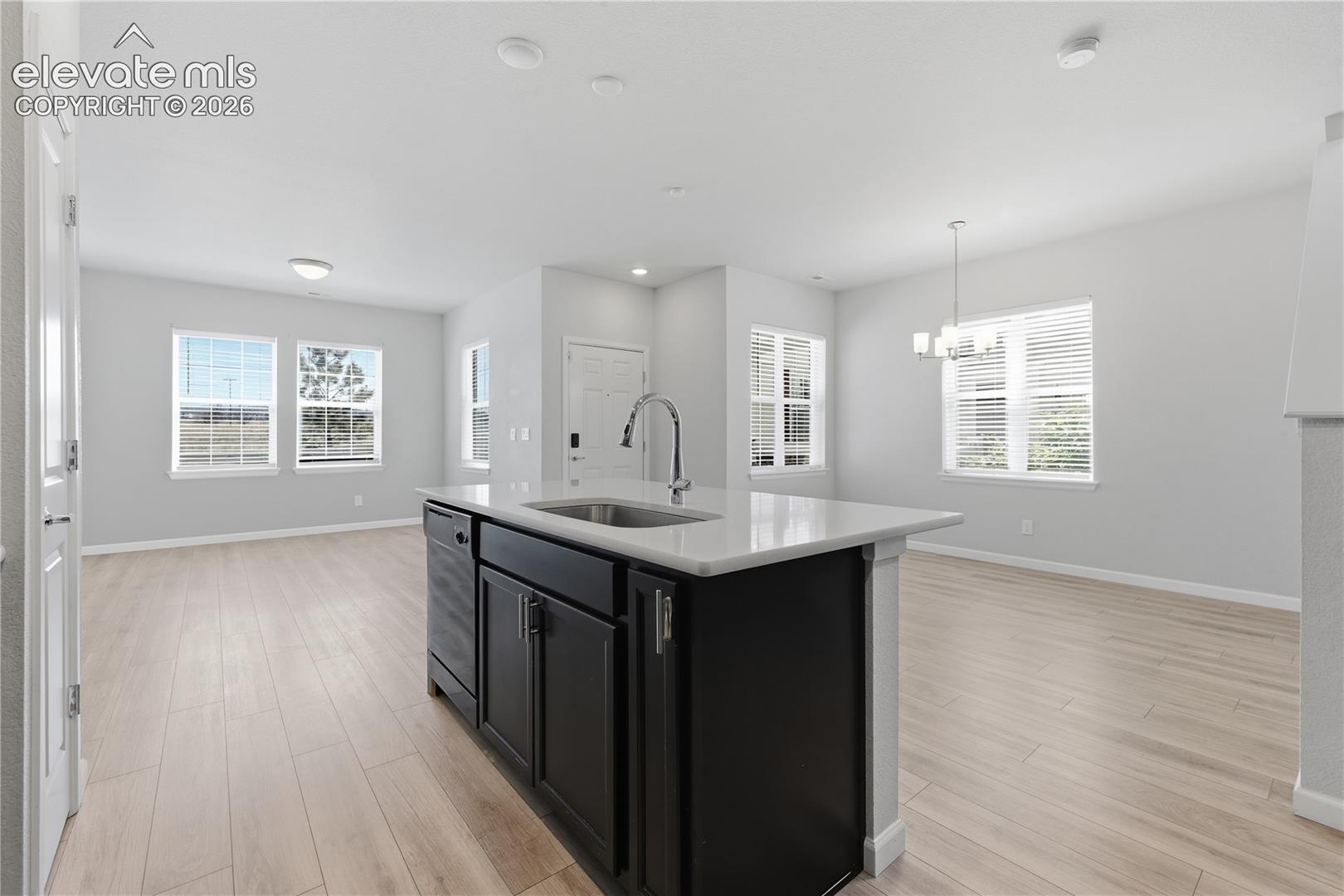 Kitchen island with a stainless steel sink, gooseneck faucet, and quartz countertop