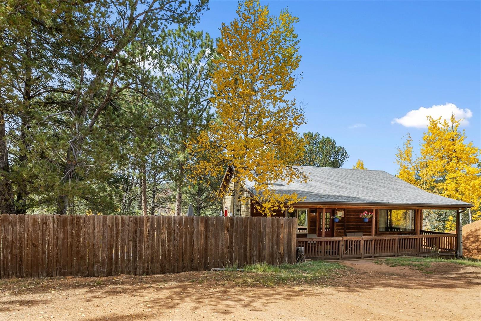 Wood siding with a covered front porch featuring a wood railing