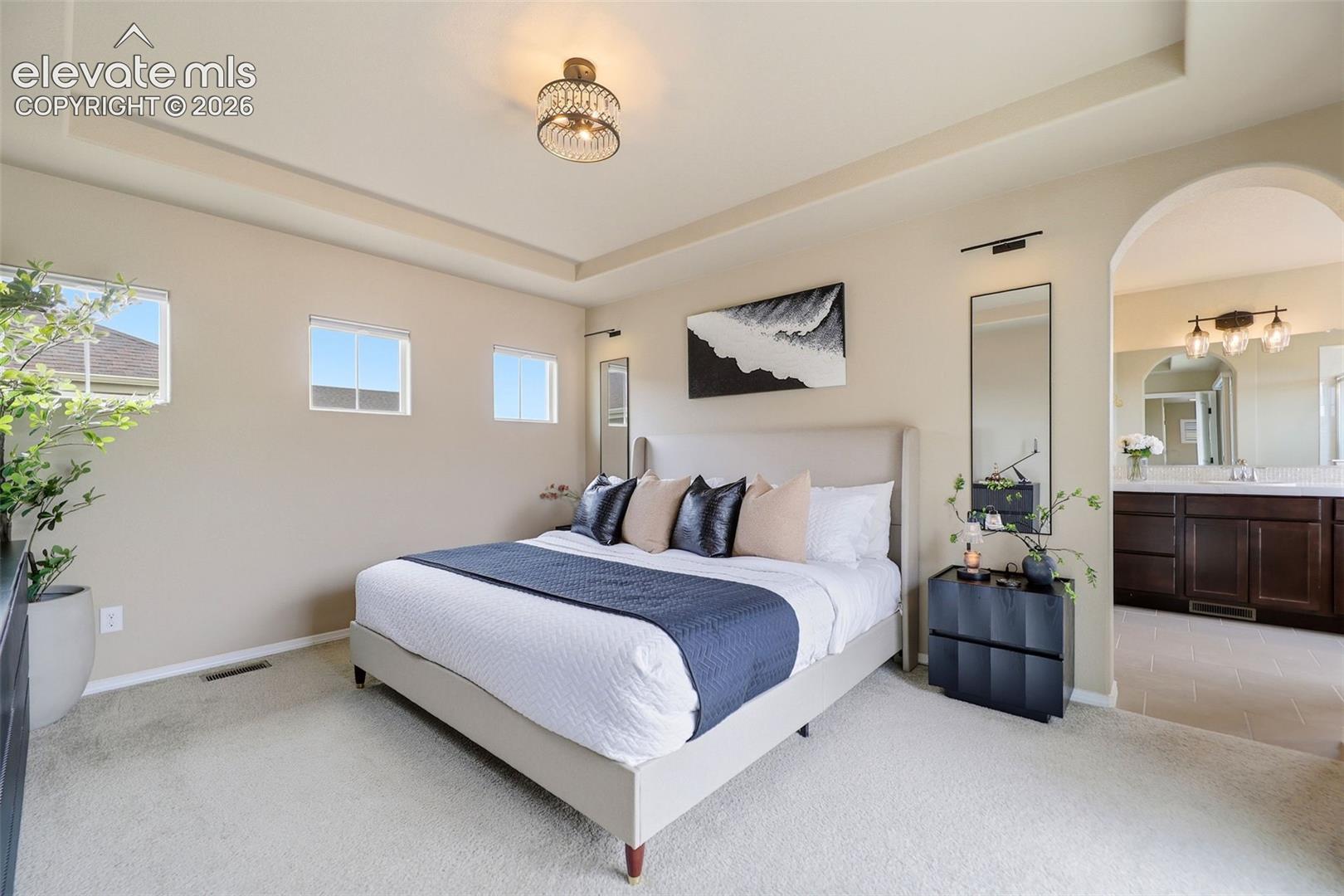 Light and bright primary bedroom, arched doorway to primary bath