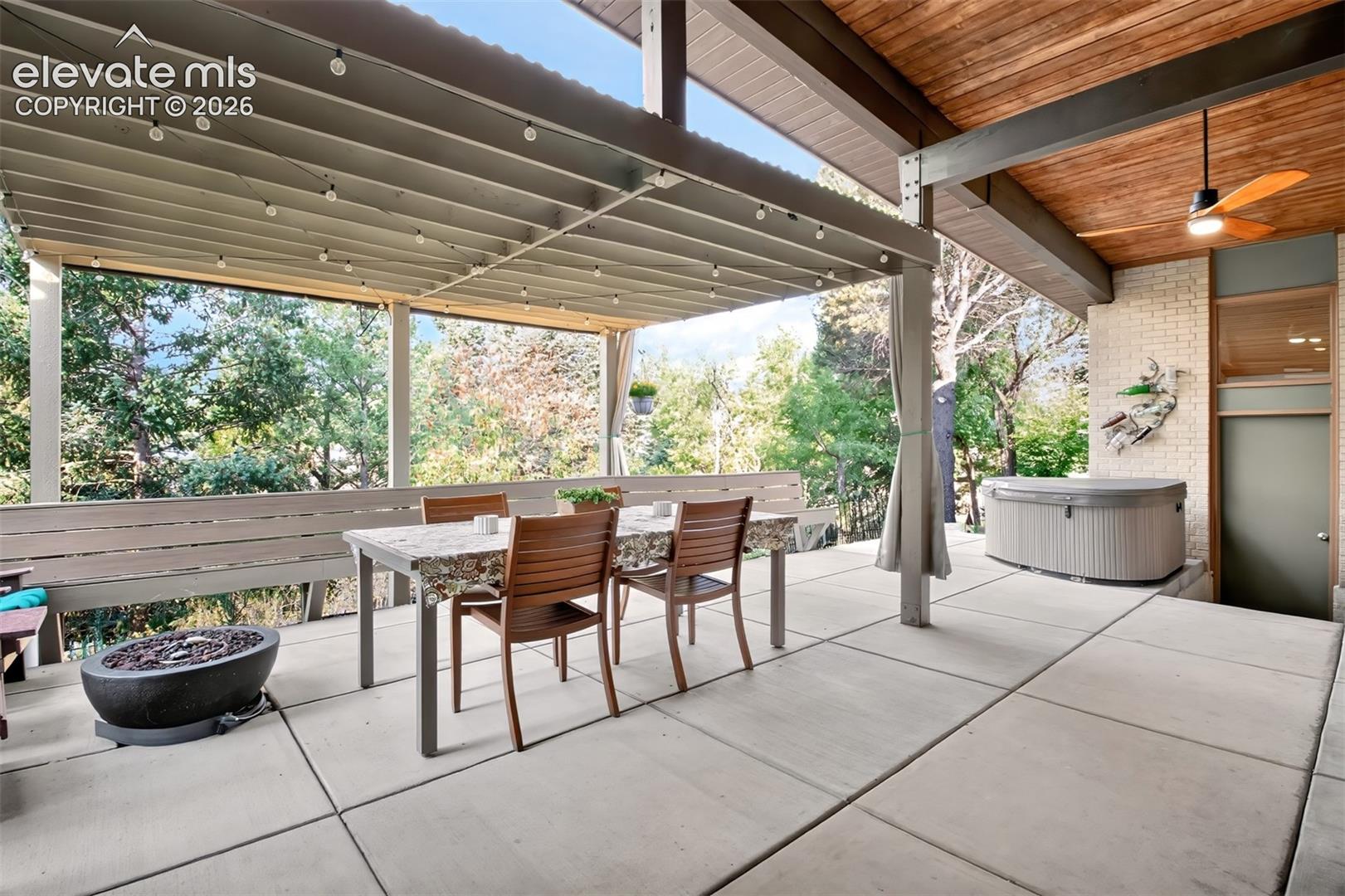 A view of the patio showing the fire pit and the hot tub that are included!