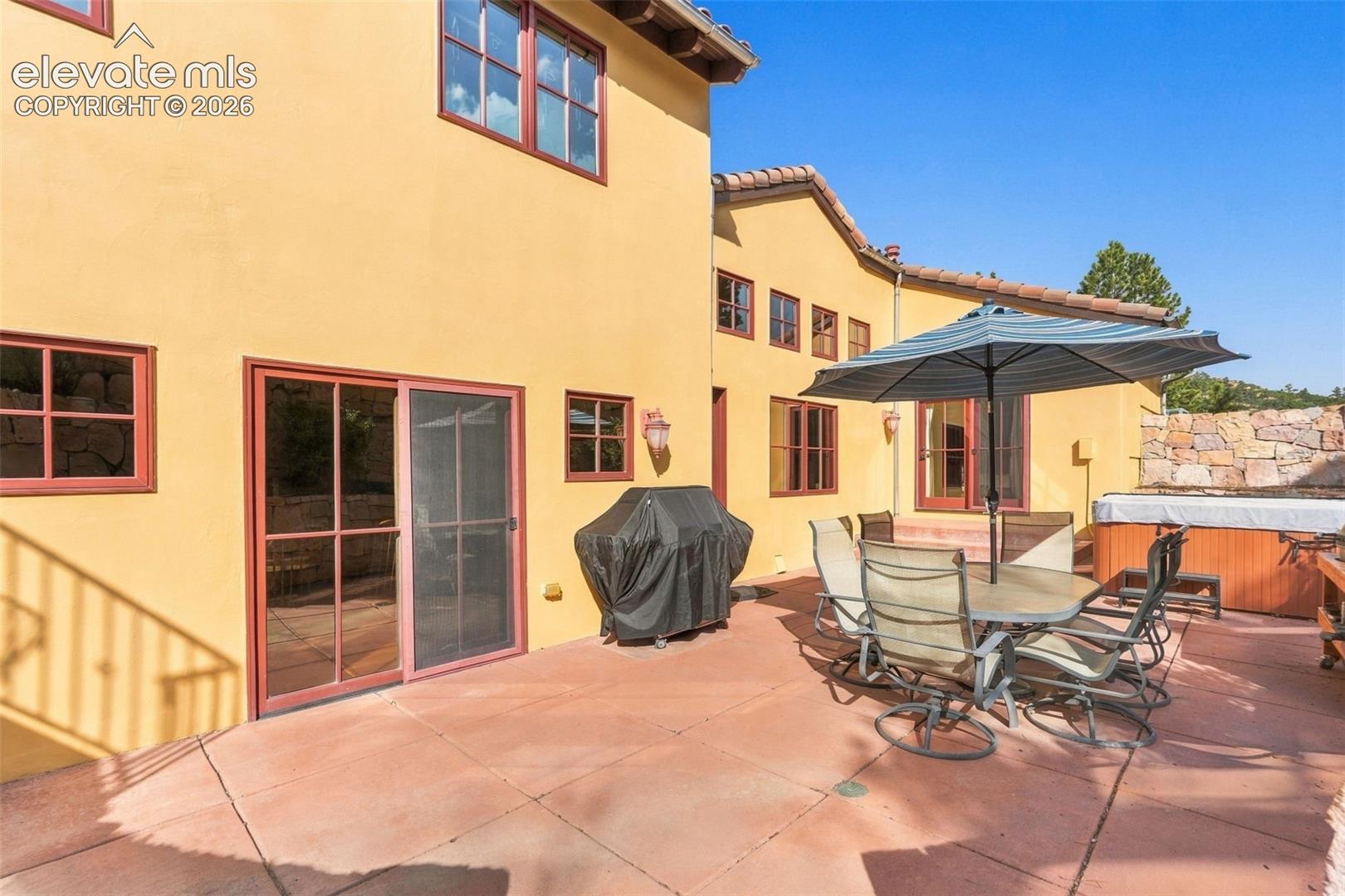 Stucco exterior with multiple windows and red trim