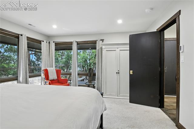 Bedroom with light colored carpet and recessed lighting