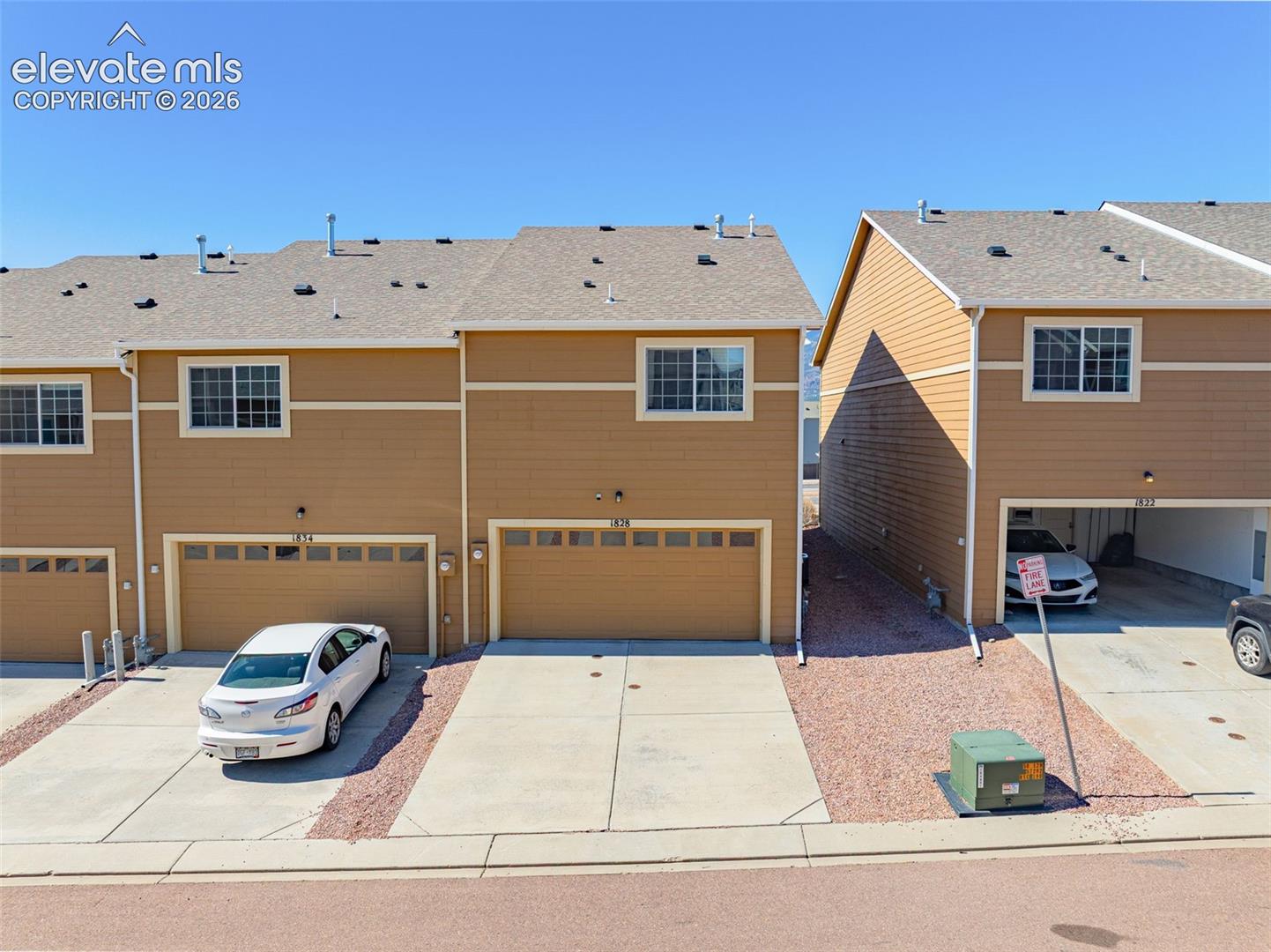 Multi-level residences featuring light brown siding and light-colored roofing