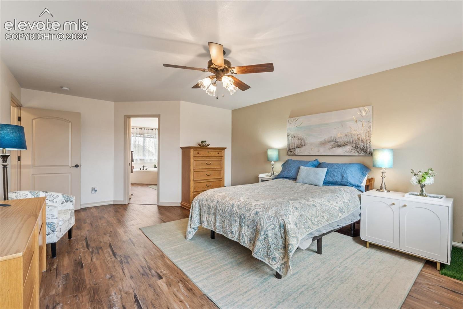 Bedroom featuring wood-finish flooring, a ceiling fan with integrated lighting, and a light-colored wall paint