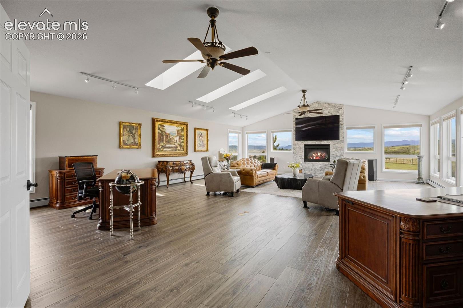Expansive living room with vaulted ceiling, three skylights, and panoramic mountain views.