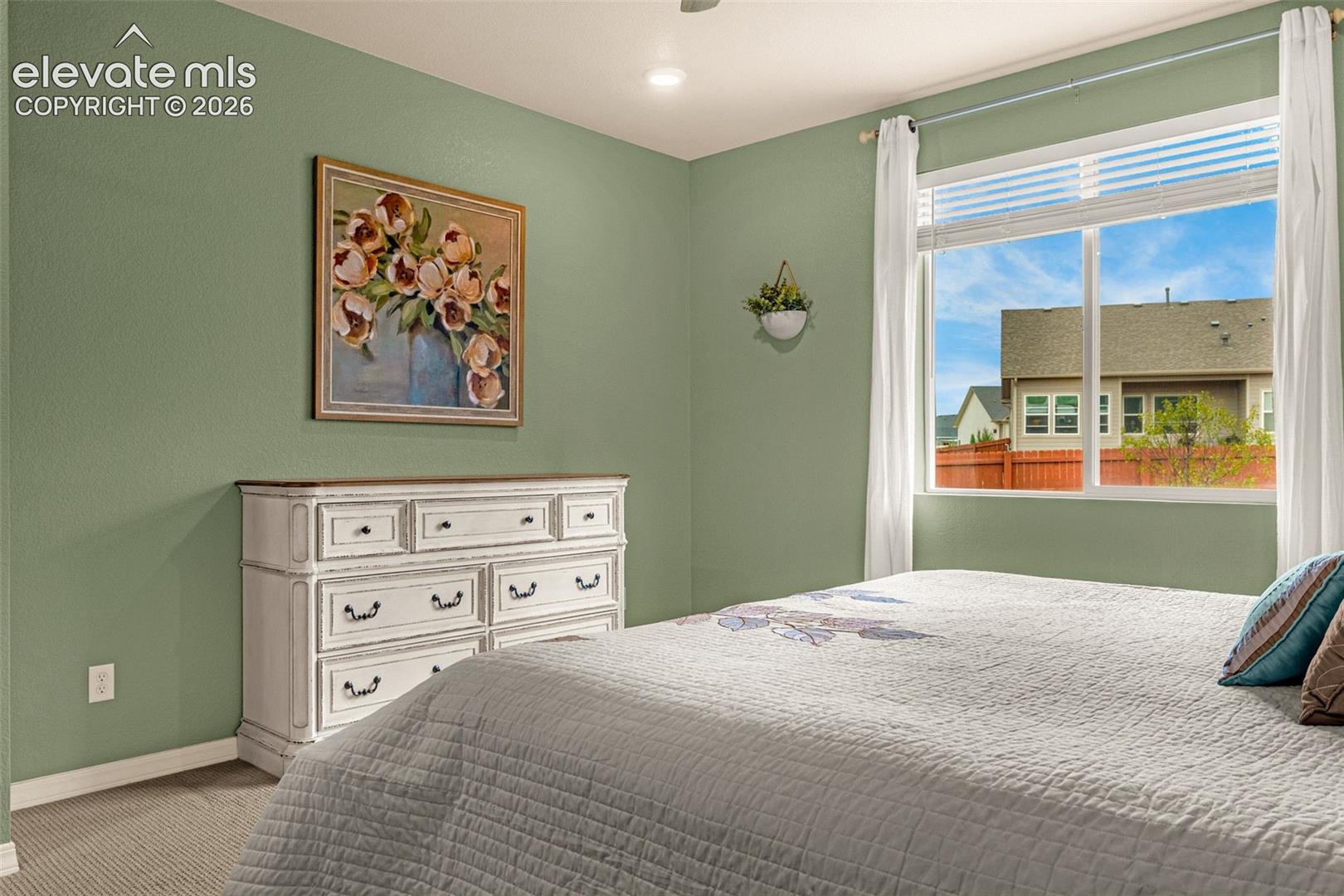 Recessed lighting, large window with blinds, light green walls, and carpeted flooring