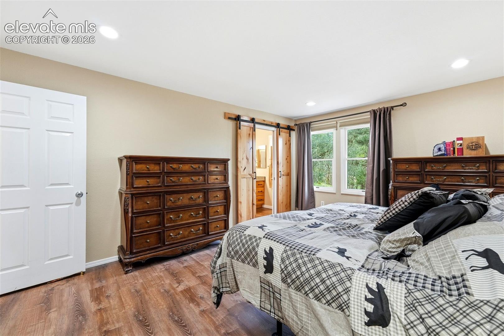 Custom barn door leads to the remodeled 3/4 bath
