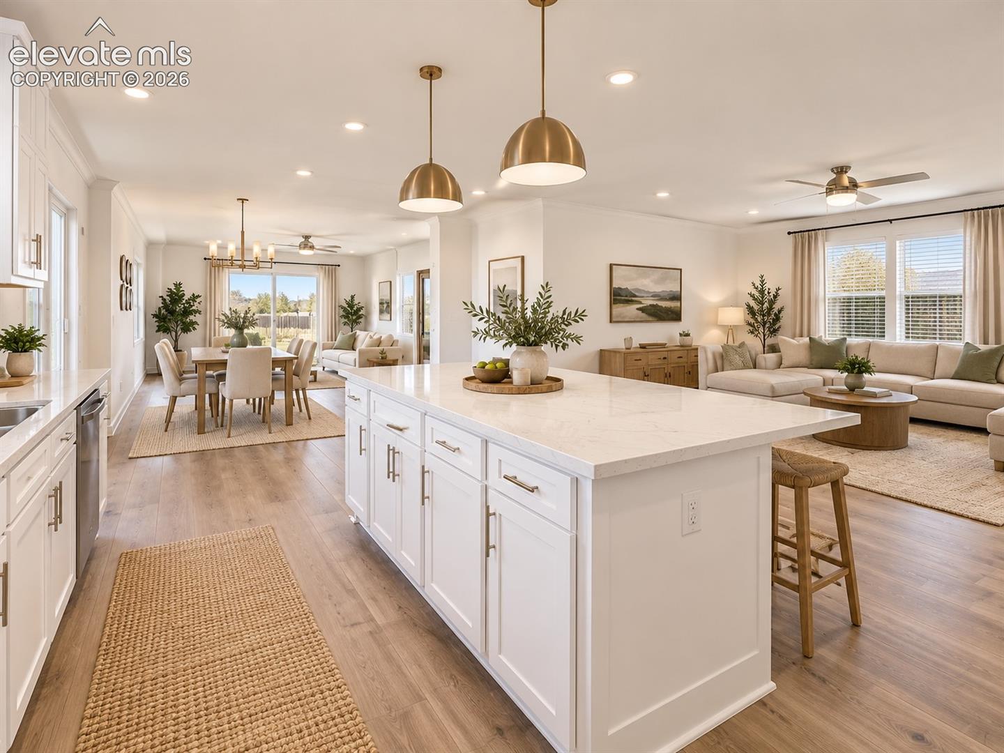 Kitchen, Dining & Living Areas – Wide-angle view showcases the open floor plan connecting the spacious kitchen island with adjoining dining and living areas for effortless everyday flow.