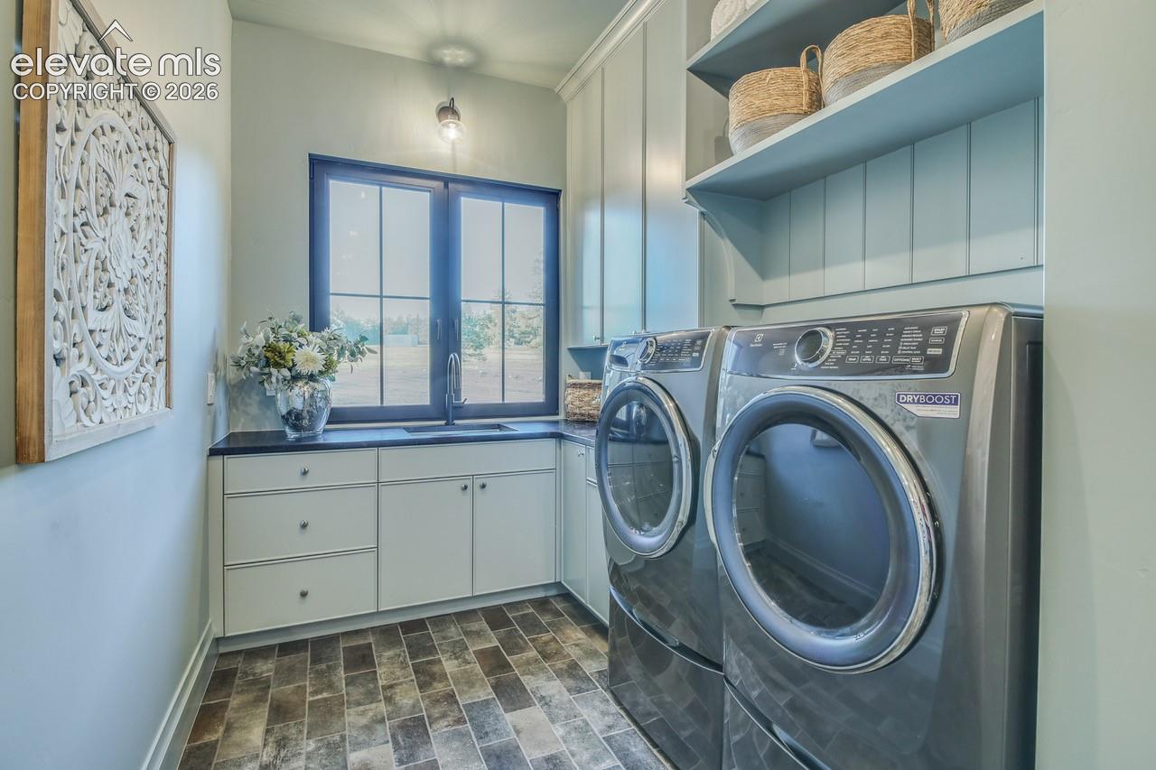This laundry room has it all, lots of cabinets, storage and sink.