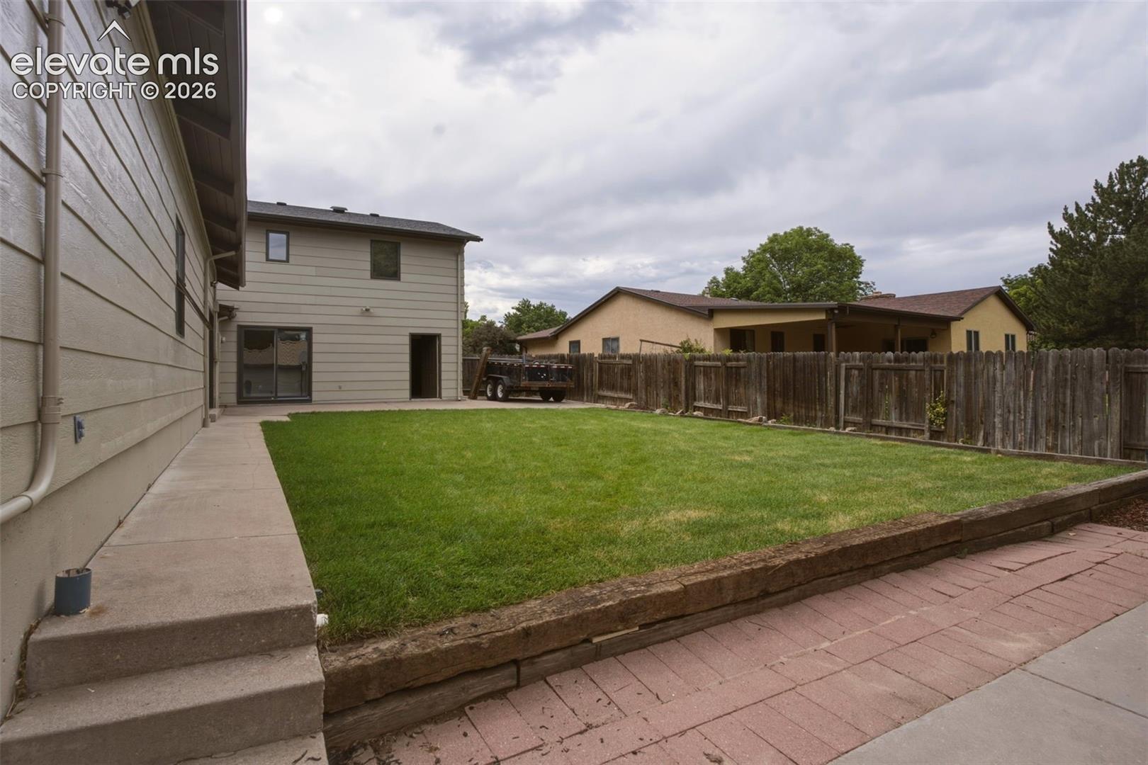 Expansive lawn area with a wood fence perimeter