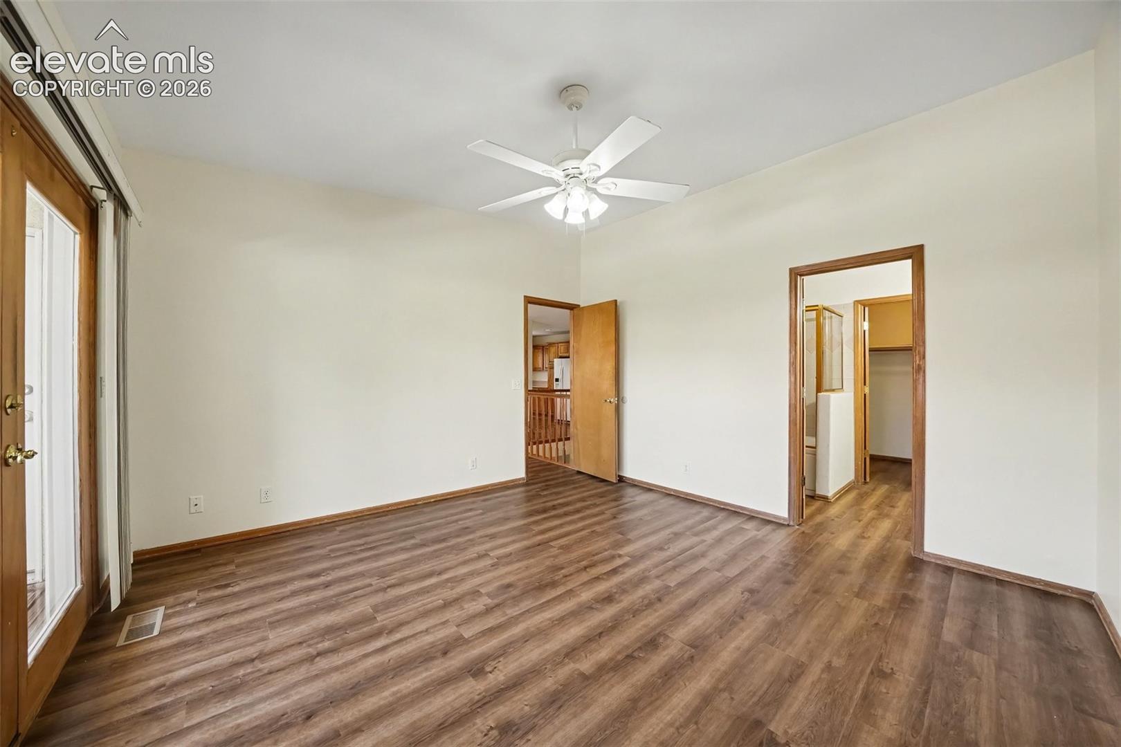 New paint and LVP flooring, ceiling fan, and doors to balcony