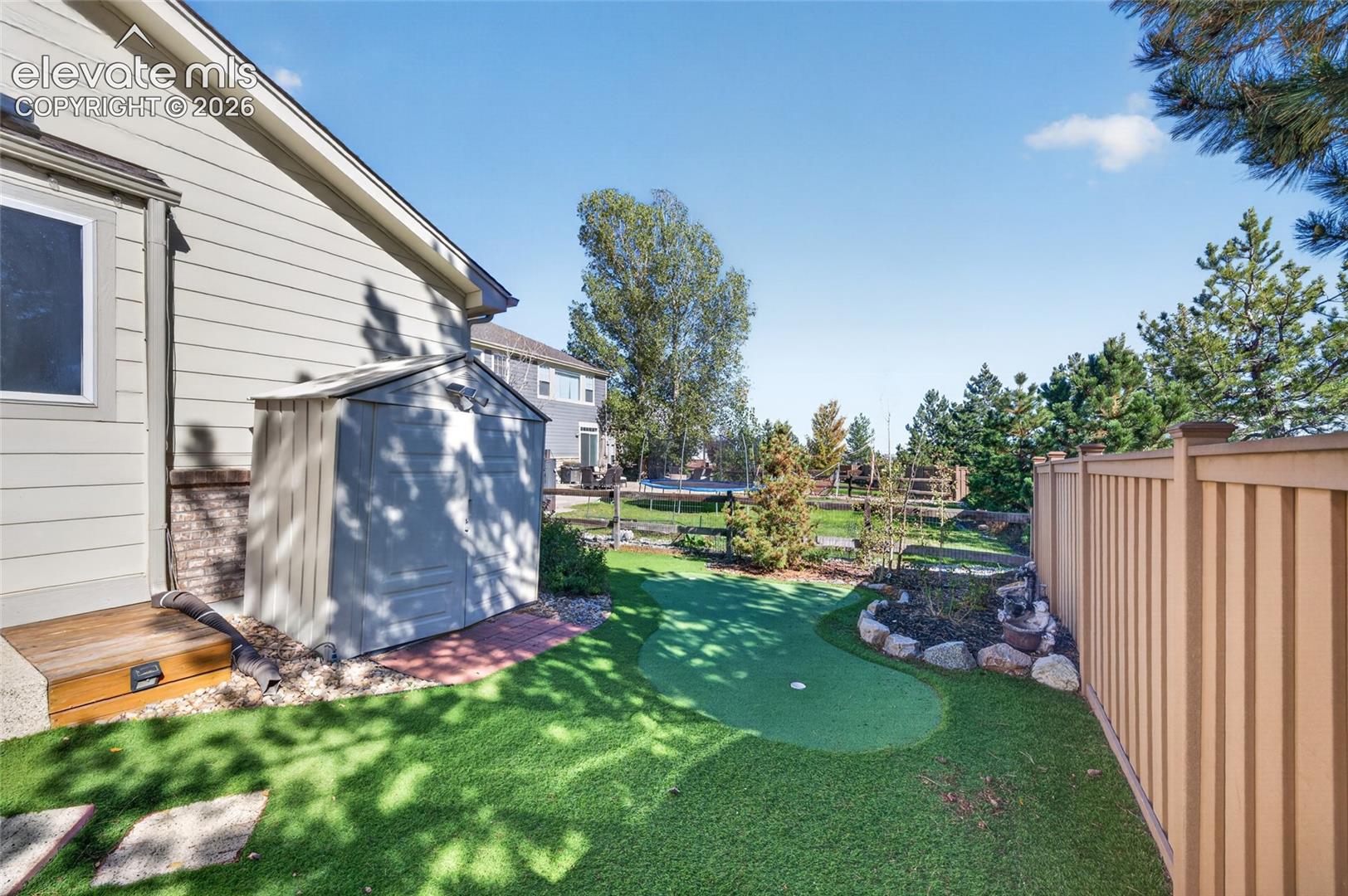 Putting green and maintenance-free turf in a fully fenced yard