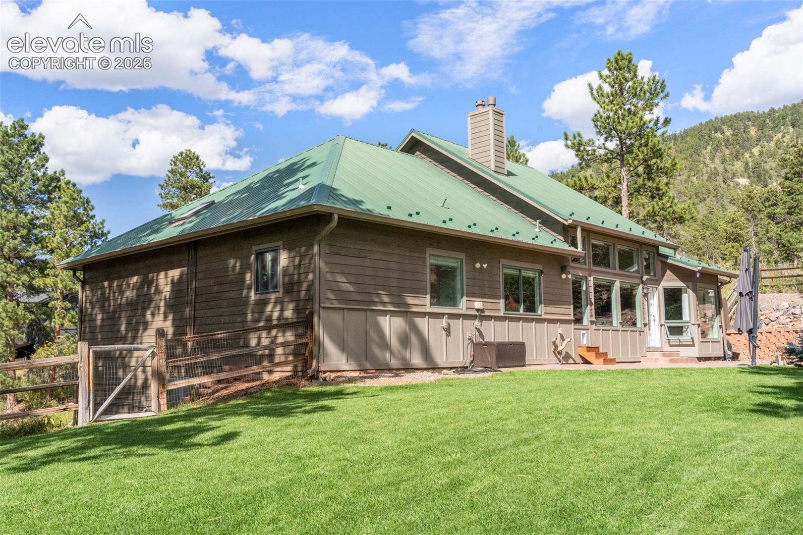 Back of house featuring a metal roof and a chimney