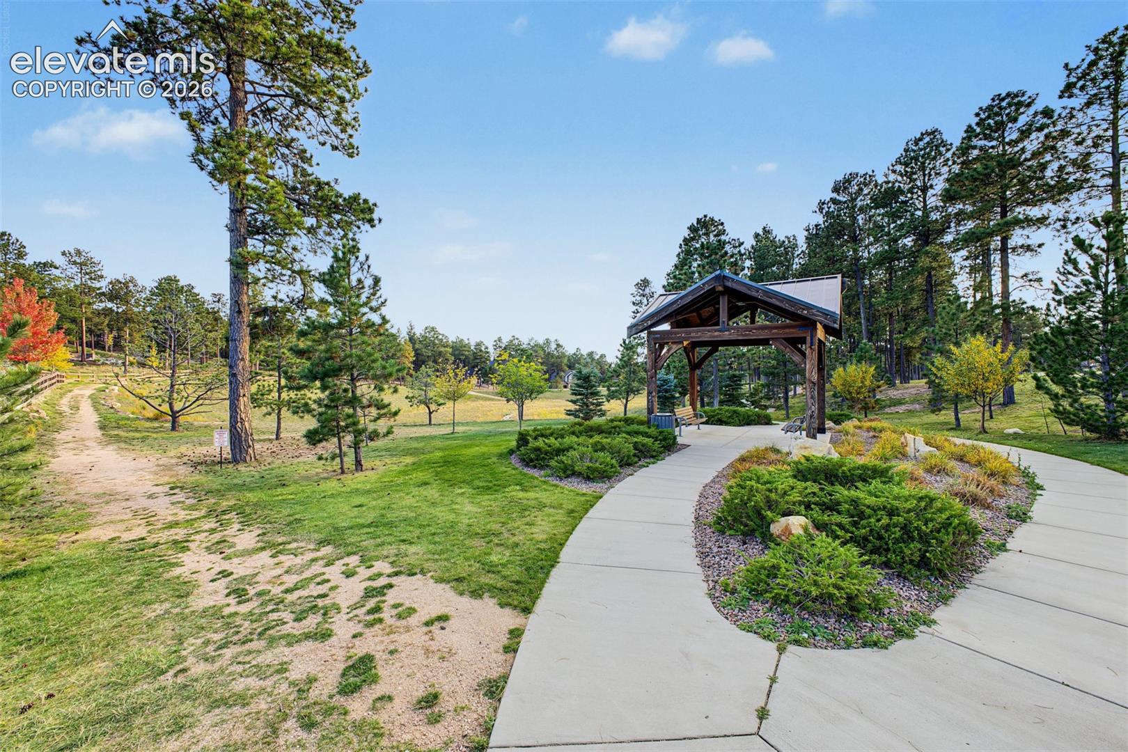 Beautifully landscaped Sanctuary Pointe pocket park featuring winding walking paths, lush green spaces, and mature trees, offering a peaceful place to enjoy the outdoors.