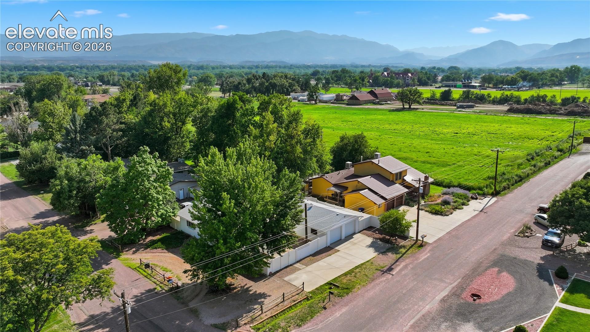 Aerial view highlights the home’s setting in an established neighborhood near the historic Abbey, with open surroundings and beautiful mountain backdrop.