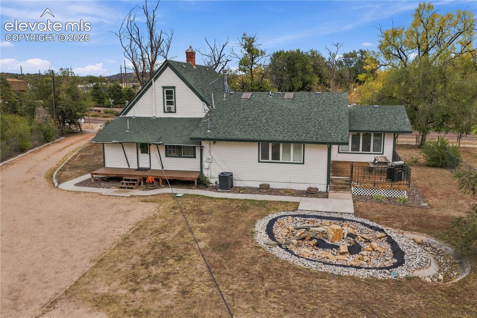 Rear view of home, back covered porch and private Primary deck